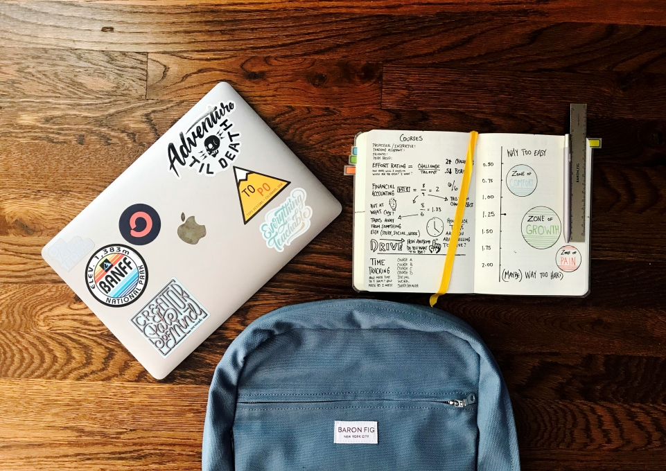 a laptop, a backpack, and a notebook